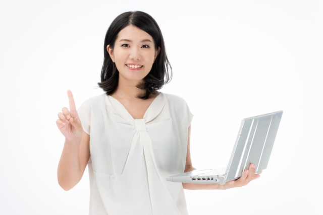 パソコンを持って指差しする女性